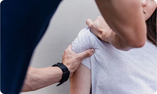 Physical therapist assisting with shoulder recovery and rehabilitation