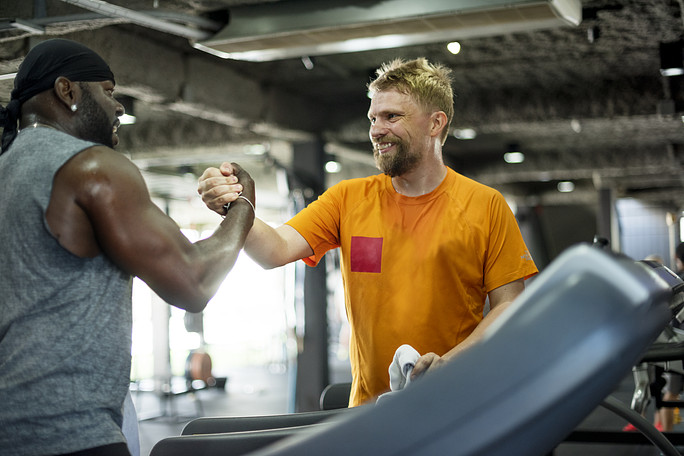 Two fitness enthusiasts shaking hands in a gym, representing VibePlate's partnerships